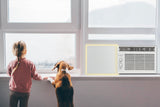Child and dog looking out a window, next to an air conditioner unit using Easy AC Screen